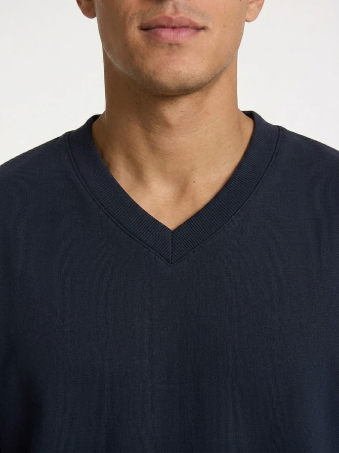 A navy V-neck fleece featuring a comfortable fit, with a visible logo on the fabric.