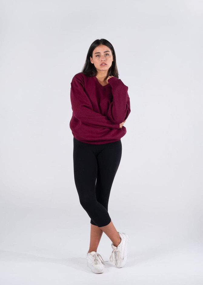 A burgundy V-neck fleece top paired with black leggings, worn by a model against a plain background.