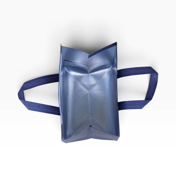 An insulated reusable bag in blue with two handles, displayed from a top-down view.