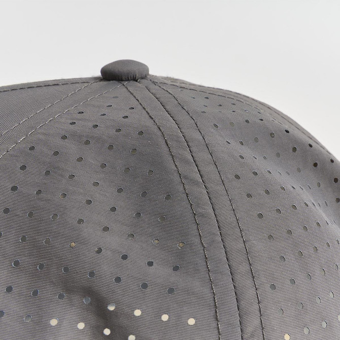 A grey cap with a perforated design, featuring small holes across the fabric. It has a rounded top button.