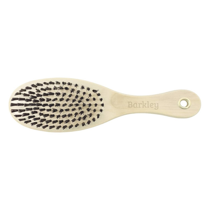 A wooden pet brush with a light handle and black bristles, featuring a branding logo on the handle.