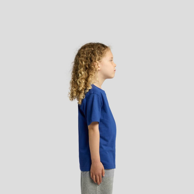 A side view of a child wearing a blue T-shirt, paired with grey shorts. The shirt has a logo on it.