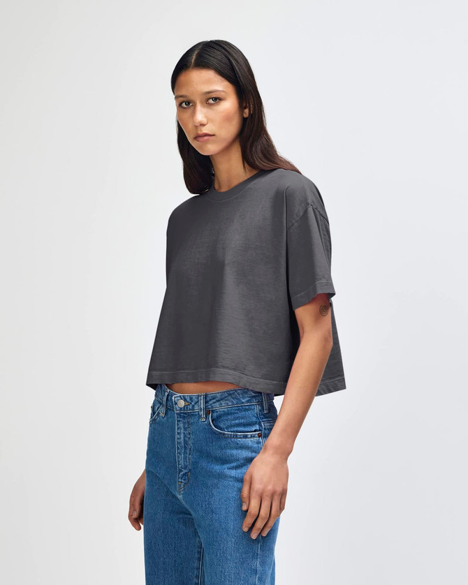 A grey cropped boxy t-shirt for women, featuring a relaxed fit and short sleeves. It has a logo on it.
