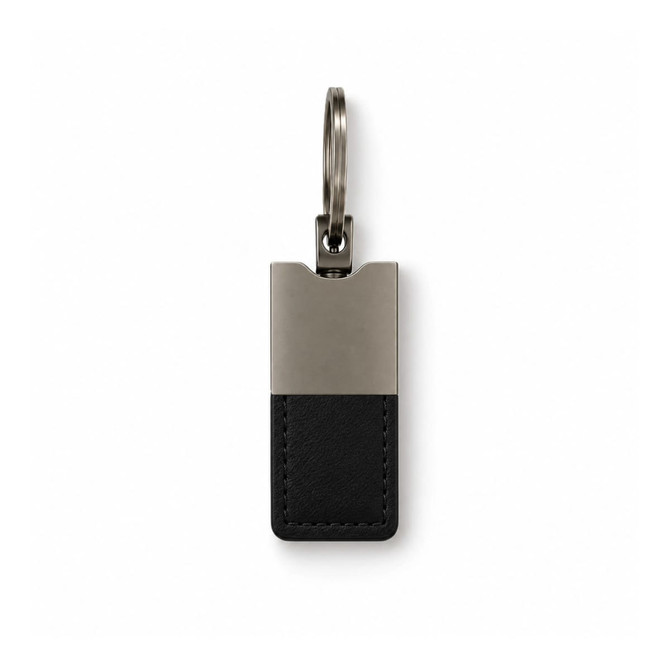 A sleek keytag featuring a black leather base and a silver metallic top, attached to a metal ring.
