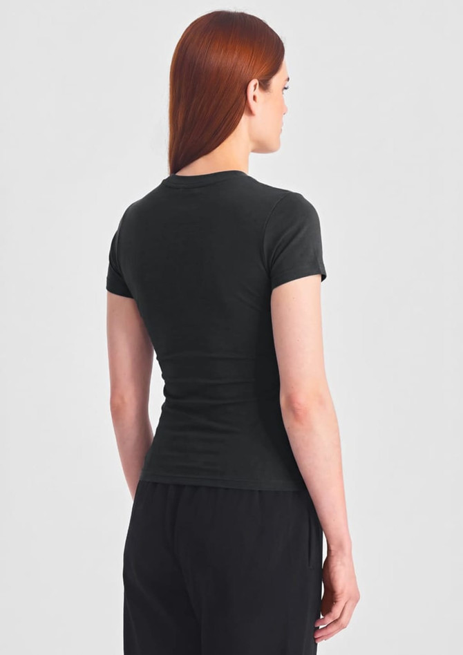 A women's black baby tee viewed from the back, featuring a fitted design and short sleeves.