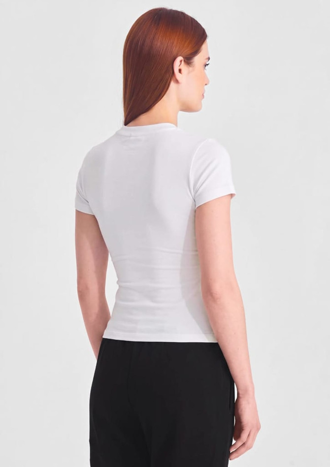 A white women's baby tee displayed from the back, featuring a fitted design and short sleeves.