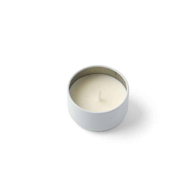 A white mini tin candle in a round container with a single wick. The container has a smooth, metallic finish inside.