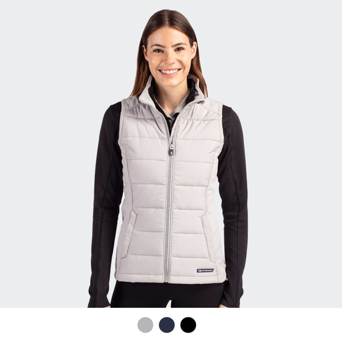 A woman wearing a light grey puffer vest with a zip front. The vest has a logo and is styled with a black top.