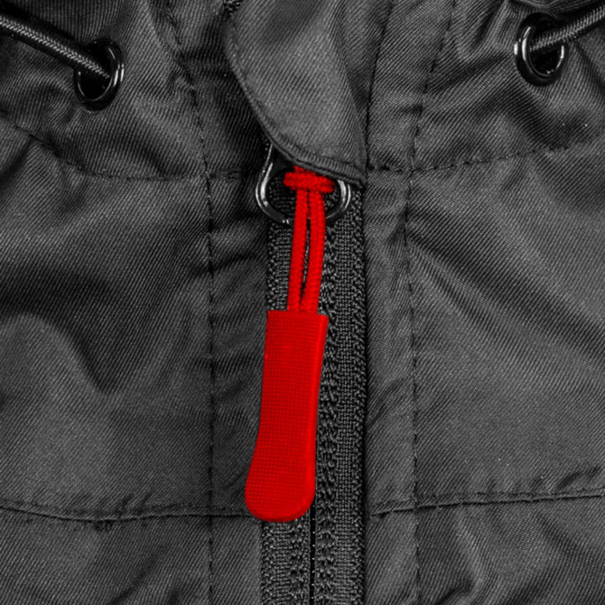 Close-up of a black windbreaker featuring a red zipper pull and adjustable drawstrings.