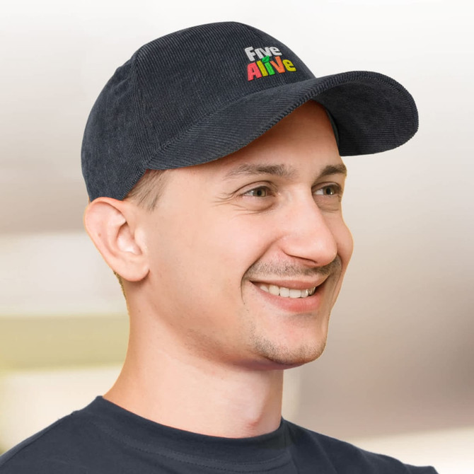 A corduroy cap in navy blue with a logo on the front, worn by a smiling man.