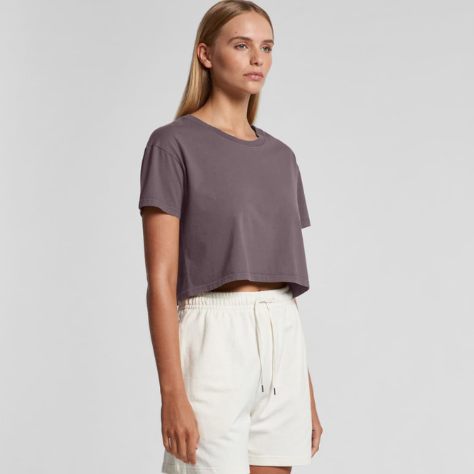 A cropped t-shirt in a muted purple colour, featuring a round neckline and short sleeves, paired with light shorts.