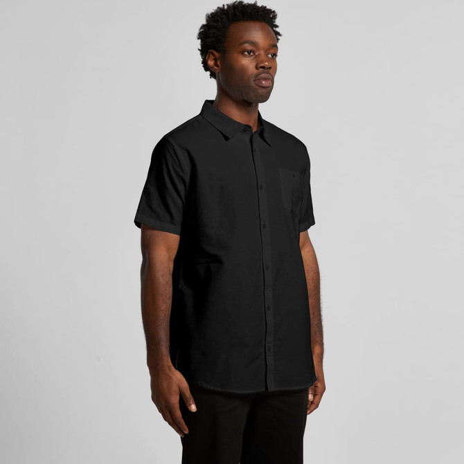 A black button-up shirt with short sleeves, featuring a subtle logo on the pocket area.