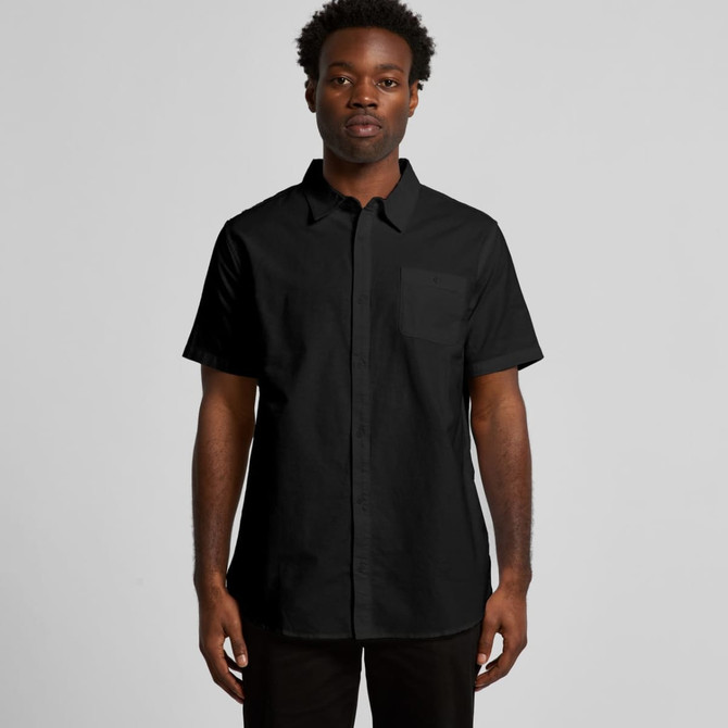 A black short-sleeve button-up shirt featuring a single chest pocket and a logo.