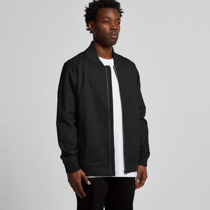 A black bomber jacket displayed on a model, featuring a zip closure and long sleeves. The jacket has a logo on it.