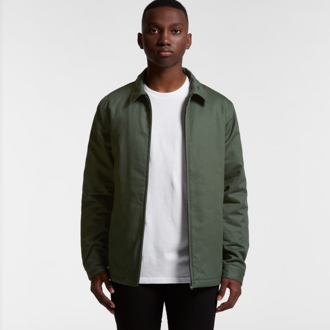 A man wearing a green service jacket over a white shirt, standing against a plain background. The jacket has a logo.