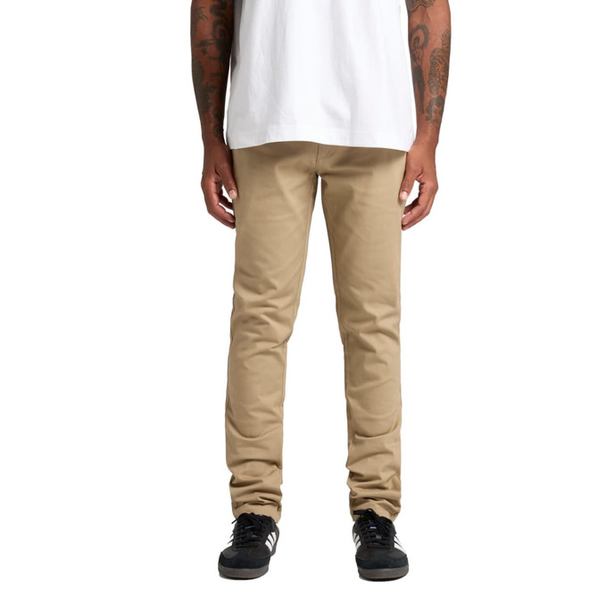 Khaki standard pants displayed on a person wearing a white shirt and black shoes. The image has a logo on the pants.