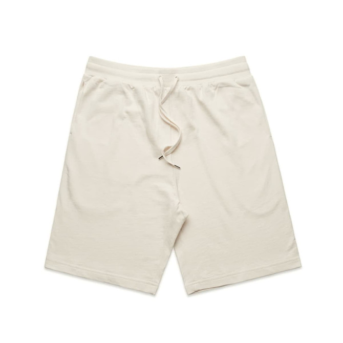 Light beige sports shorts with an elastic waistband and drawstring, featuring a logo on one side.