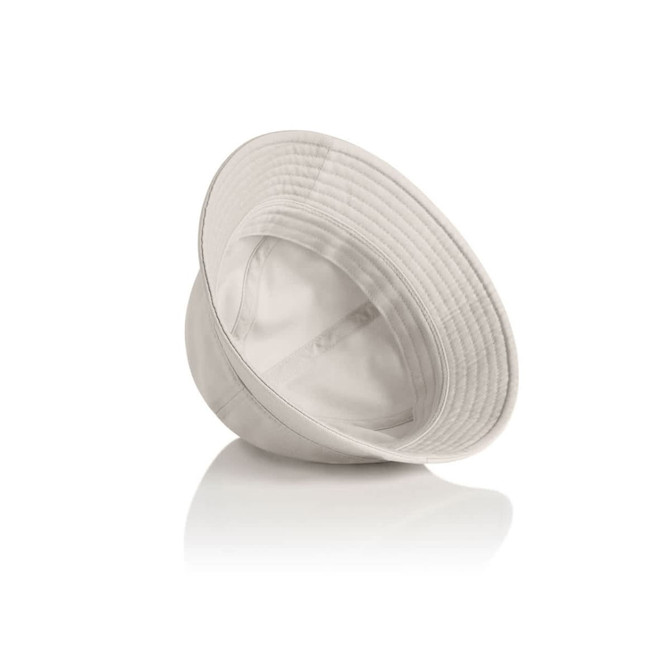 A light beige bucket hat with a wide brim and a logo inside. It rests on a reflective surface.