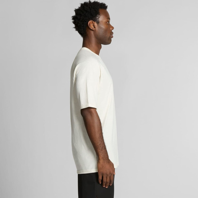 A side view of a cream-coloured t-shirt worn by a model, featuring short sleeves and a simple design.