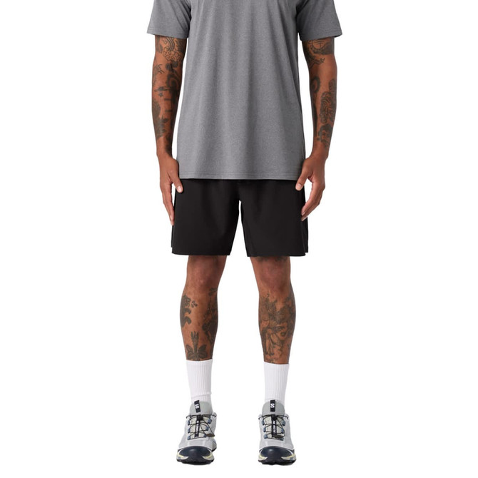Active Pro Shorts in black, featured on a model wearing a grey shirt and athletic shoes. The model has visible tattoos.