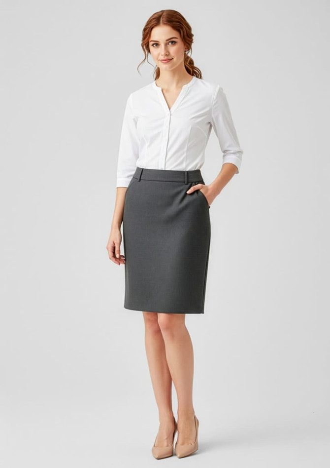 A grey women's comfort wool stretch skirt with pleats, paired with a white blouse. The model has red hair and is wearing nude heels.