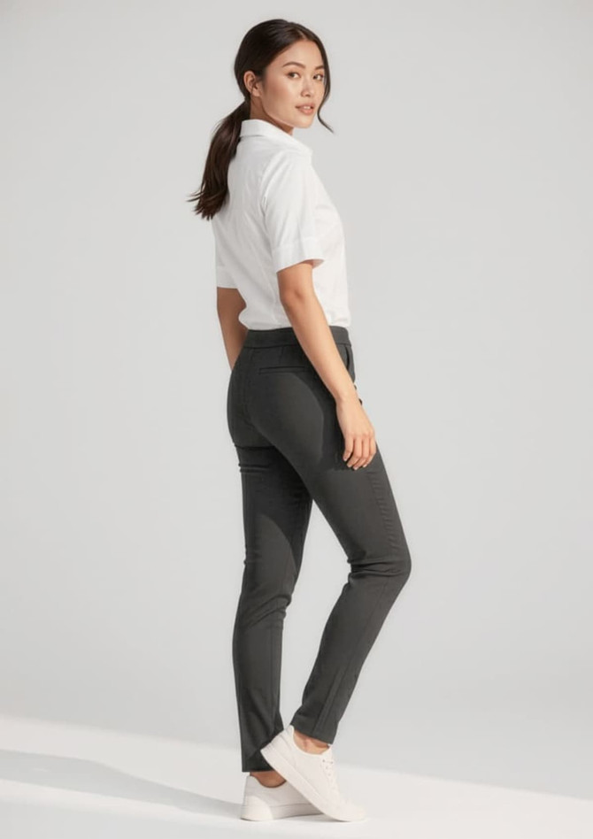 A pair of women's stretch pants in black, worn with a white shirt and white sneakers, featuring a logo.