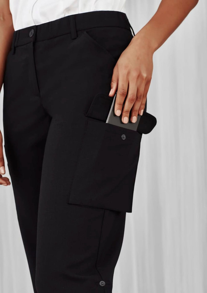 A pair of black women's cargo pants featuring side pockets and a logo, with a hand reaching for a phone.