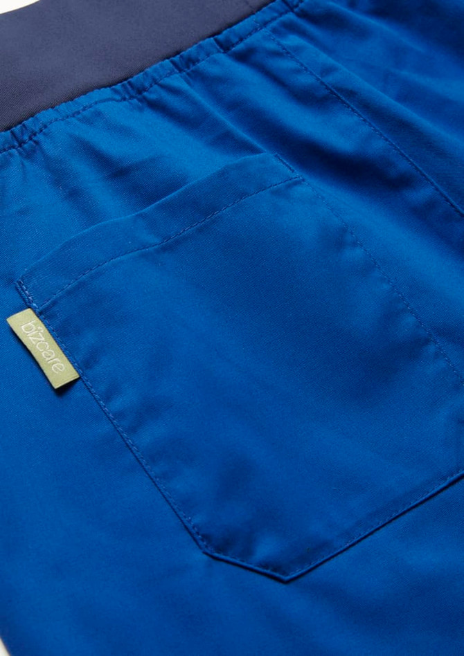 A close-up of blue women's jogger scrub pants featuring a back pocket and waistband. Includes a logo tag.