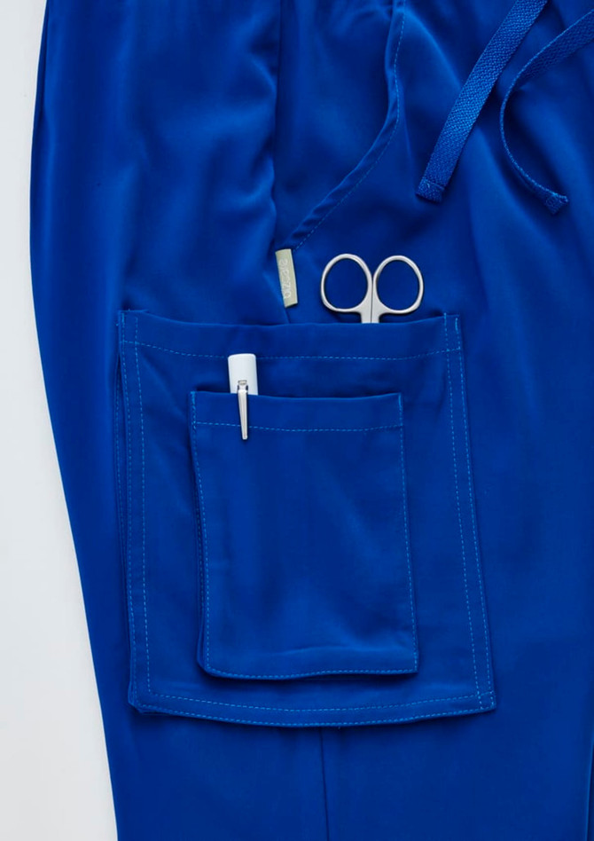 A pair of royal blue straight leg scrub pants featuring a large pocket with scissors and a pen.