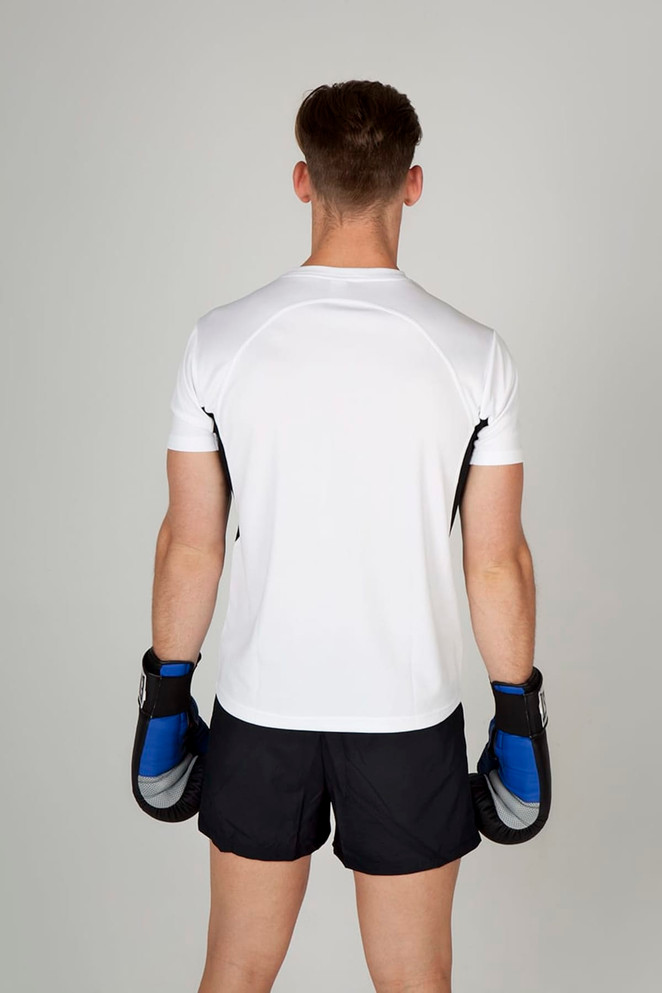 A man wearing a white cool dry T-shirt and black shorts, holding boxing gloves, viewed from the back.