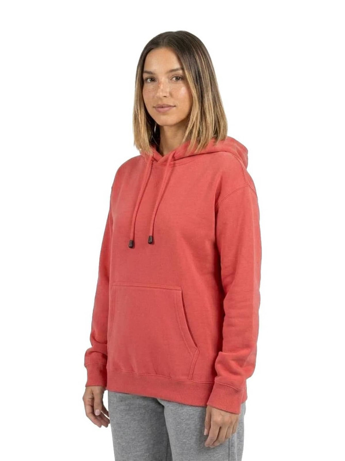 A coral women's hoodie with a kangaroo pocket, featuring a drawstring hood and a logo. Model wearing paired with grey pants.