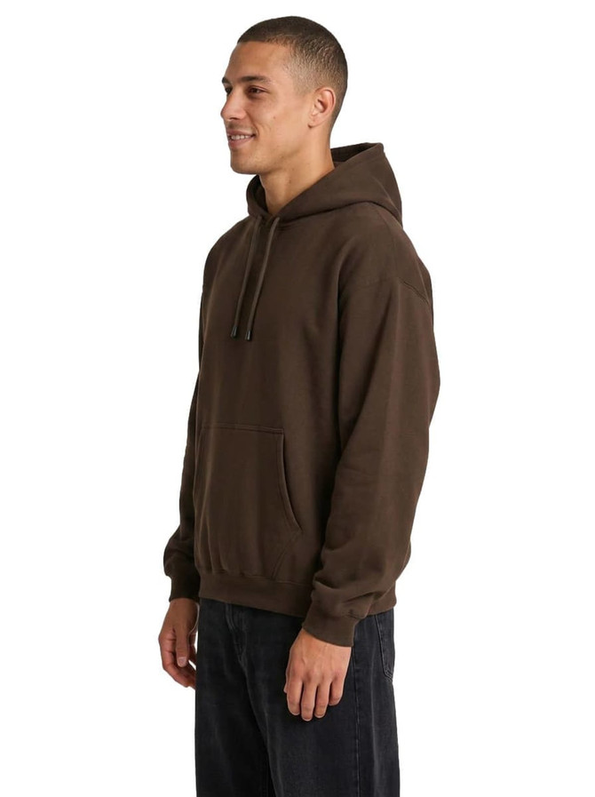 A brown men's kangaroo pocket hoodie is displayed on a model standing sideways. The hoodie features a front pocket and a hood.