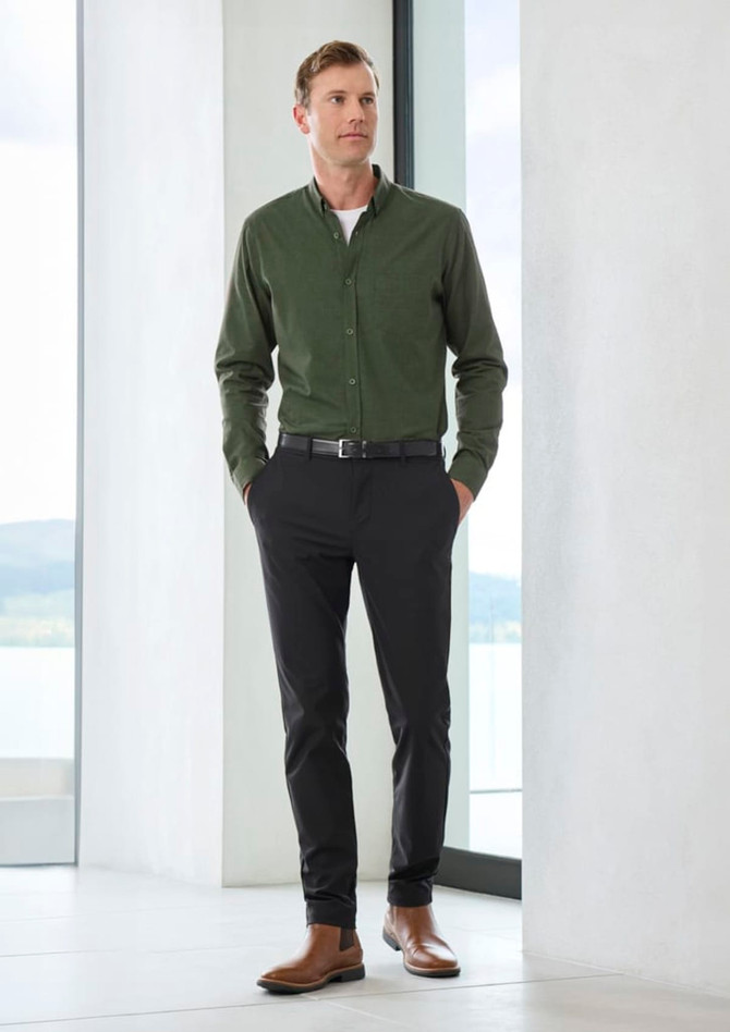 A green long sleeve button-up shirt worn with black pants and brown shoes, featuring a simple logo.