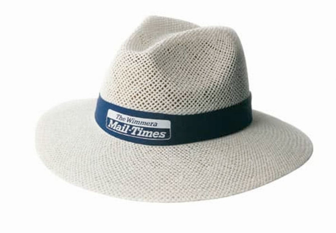 A cream-coloured straw hat with a navy band and a logo, featuring a wide brim and a textured design.
