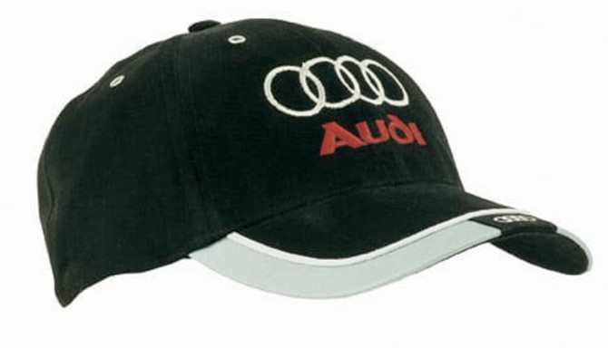A black brushed heavy cotton cap with reflective trim and tab on the peak, featuring a logo on the front.