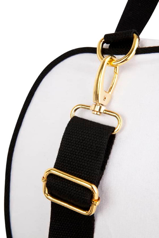 A close-up of a black strap with gold hardware attached to a white bag, featuring a logo on the surface.