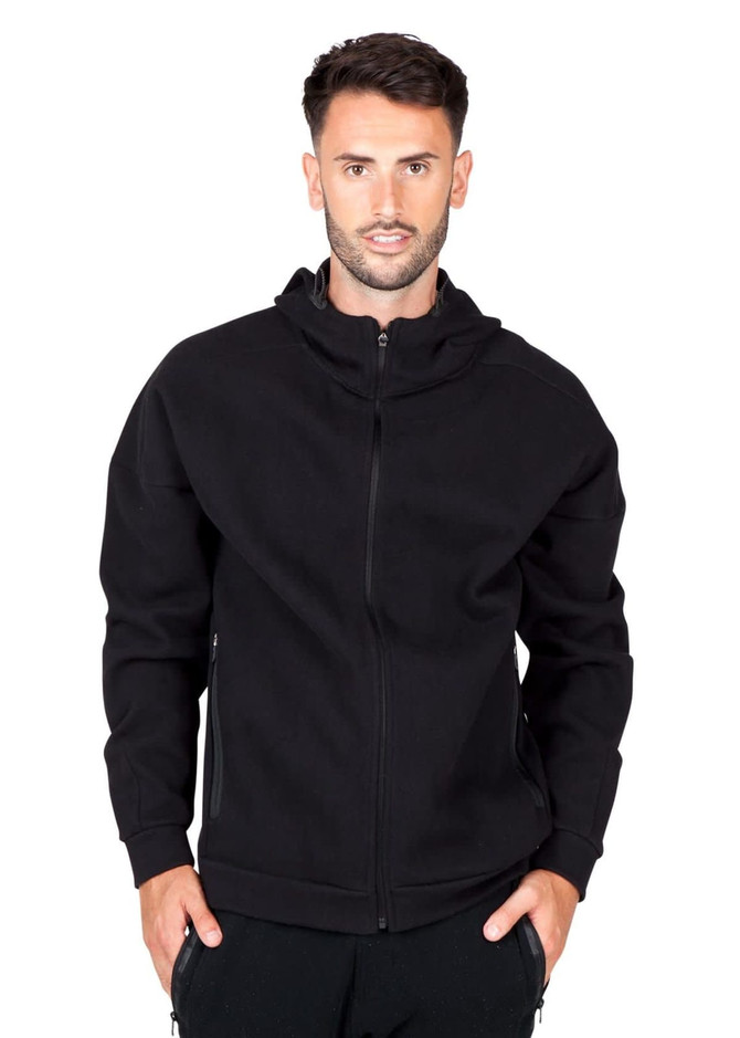 A black hoodie with a front zip and a hood, featuring a logo on one side. The model is wearing it.