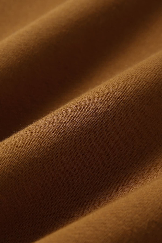 A close-up of a brown cotton fabric with subtle texture, suitable for a sweatshirt. It features a logo.