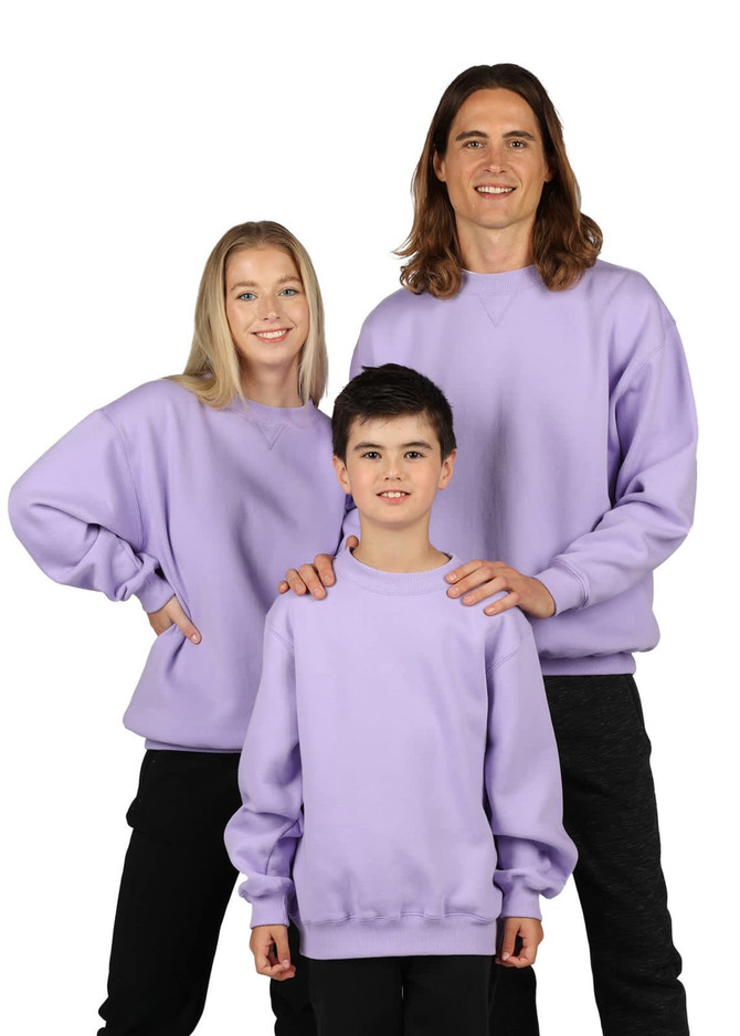 A light lavender crew neck jumper displayed on a group of three people, including adults and a child. The garments have a logo.