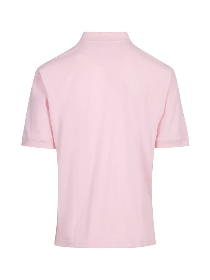 A light pink men's cotton pigment dyed polo shirt, featuring a collar and short sleeves, with a logo on the chest.