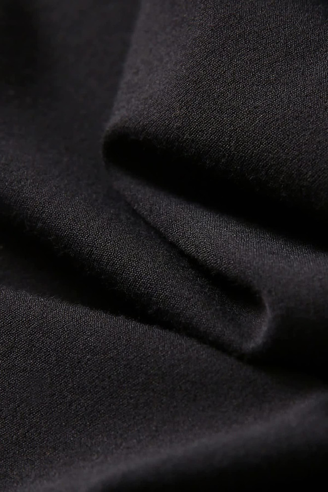 A close-up of soft, black fabric, showcasing the texture and drape suitable for leggings.