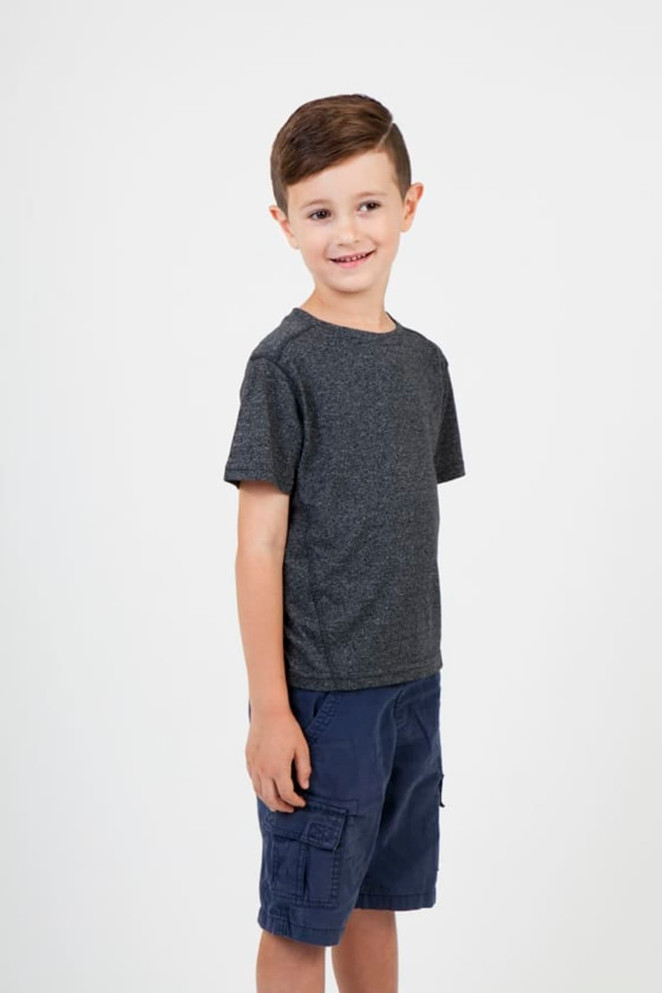 A child wearing a grey heather t-shirt and navy shorts, smiling and standing against a plain background.