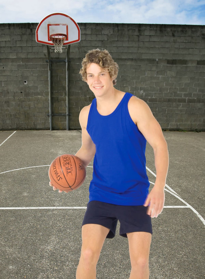 A young man in a blue cotton singlet and shorts holds a basketball on an outdoor court with a hoop in the background.