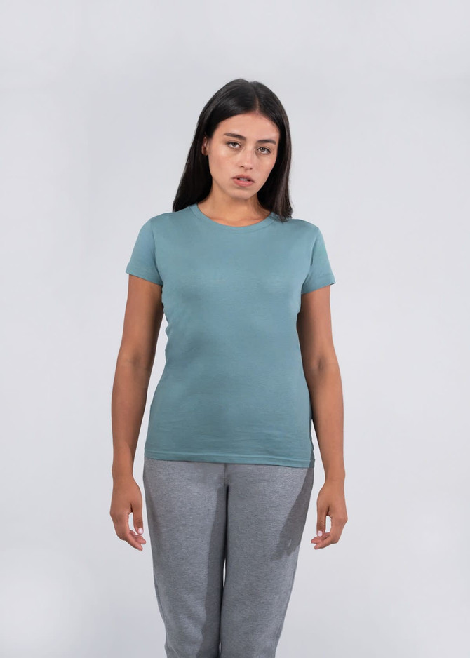 A women's fitted T-shirt in a soft teal colour, displayed on a model wearing grey pants.