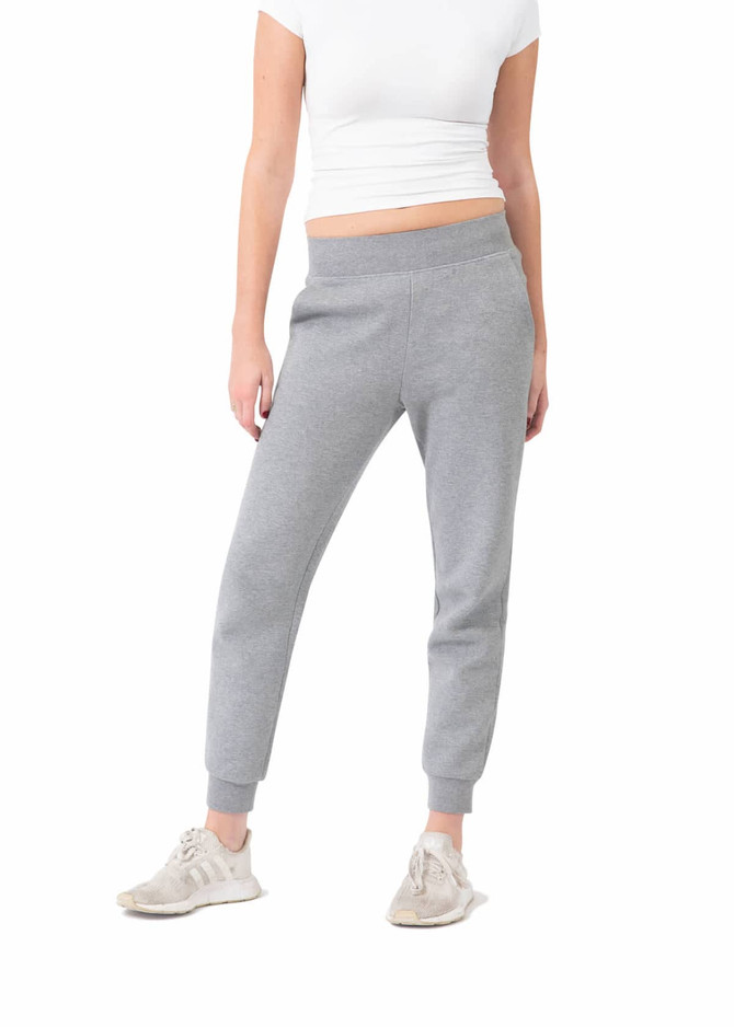 Grey women's track pants with a tapered fit and elasticated waistband, paired with light-coloured footwear.