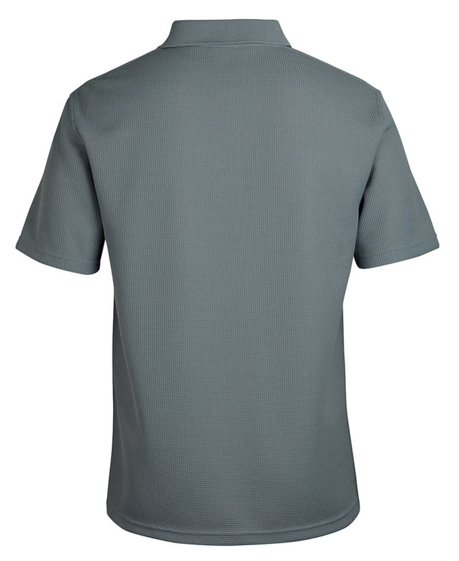 A polo shirt in a muted green colour, featuring a textured fabric and a collar. The back view is displayed. 
