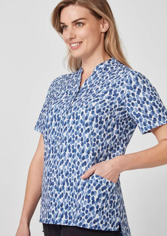 A short-sleeve tunic in blue with a stardust print, featuring a collar and side pockets, alongside a model.