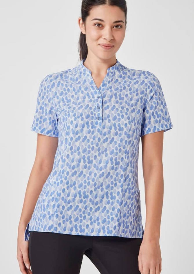 A women's tunic in blue and white with a stardust print, featuring a collar and short sleeves. It has a logo.