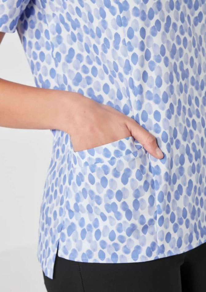 A light blue tunic with a stardust print, featuring a side pocket and short sleeves.