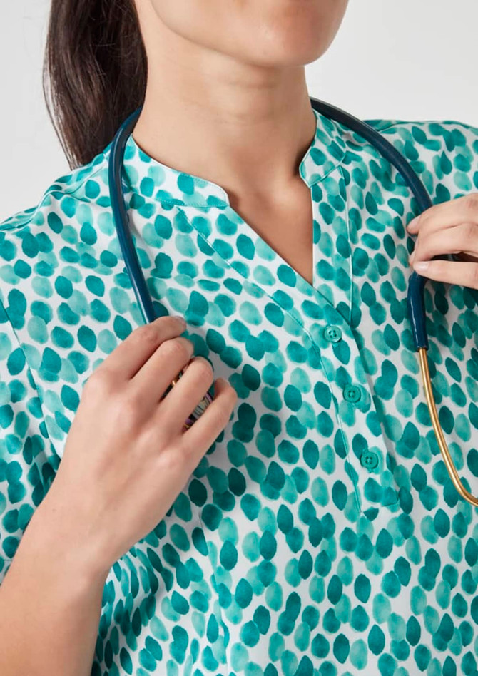A turquoise tunic featuring a starlit print, with a collar and button detailing, paired with a stethoscope.